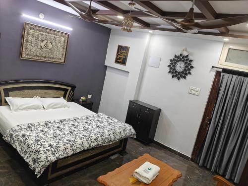 a bedroom with a bed and a table in it at Khaleel Manzil Luxe Stays in Hyderabad