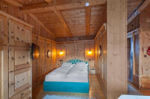 a bedroom with a bed in a wooden room at Appartement Seebacher in Hochfilzen