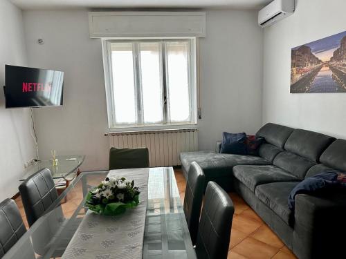 a living room with a couch and a glass table at Ziva's house apartment in Abbiategrasso in Abbiategrasso