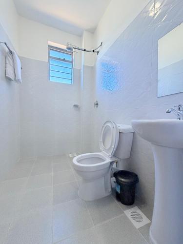 a white bathroom with a toilet and a sink at Sacred Crown Suites in Naivasha