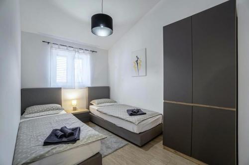 a bedroom with two beds and a black cabinet at Casa Maja in Brtonigla