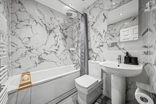 a bathroom with a sink and a toilet and a tub at London Gem - Private Parking & Patio, 7m to Station in Streatham Vale