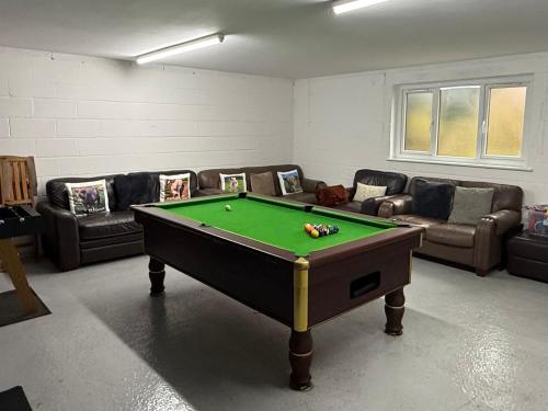 a living room with a pool table and couches at The Farmhouse at Moss Bank Farm in Wrexham