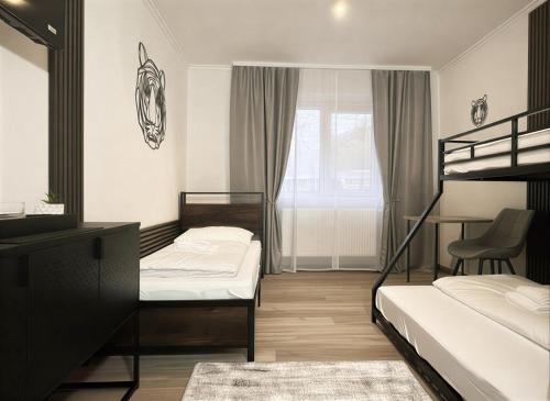 a bedroom with two bunk beds and a desk at Zemlinsky Loft Bunk Room in Payerbach