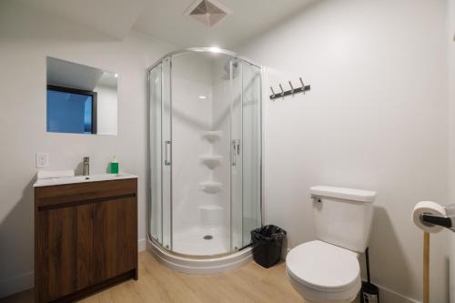 a bathroom with a shower with a toilet and a sink at Complexe la Falaise in Rivière-du-Loup