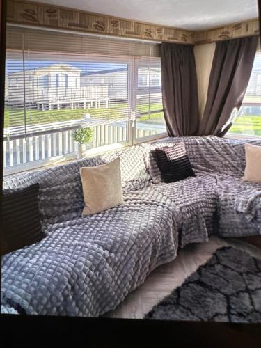 a large bed in a bedroom with a large window at Sandylands caravan park in Stevenston