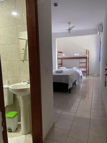 a hospital room with a bed and a sink at Hotel Costa Rio in Rio das Ostras