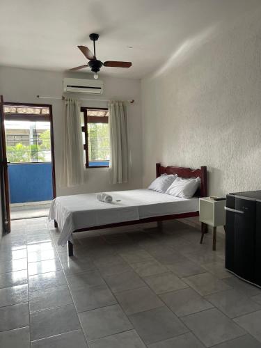 a bedroom with a bed and a ceiling fan at Hotel Costa Rio in Rio das Ostras
