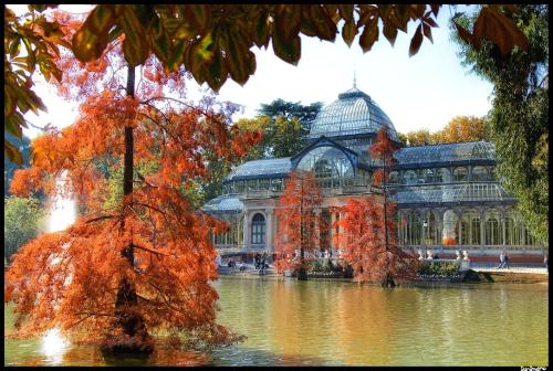 a large building with a fountain in front of a pond at Hotel Regina in Madrid