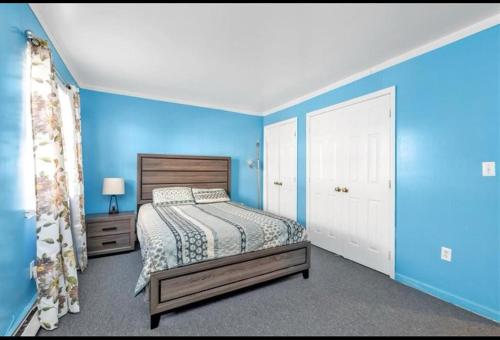 a bedroom with blue walls and a bed in a room at Large 3-Bedrooms/2-Bath Apt, One Block to Train in Brooklyn