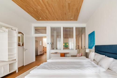 a bedroom with a large white bed with a blue headboard at Antonius Art-Loft in Waldshut-Tiengen