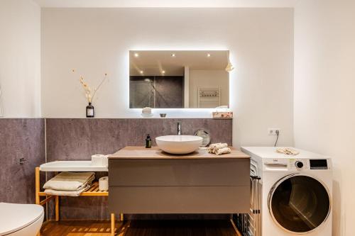 a bathroom with a sink and a washing machine at Antonius Art-Loft in Waldshut-Tiengen