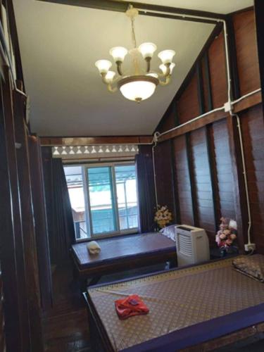 a room with a bench and a chandelier at Ruen Rinna home stays in Surin