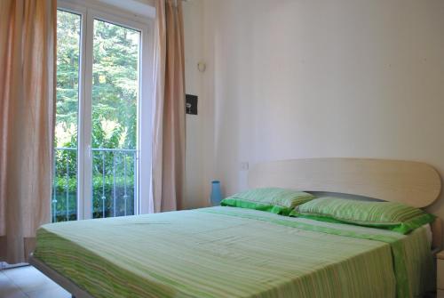 1 dormitorio con 1 cama y ventana grande en Residence White Beach en Lierna