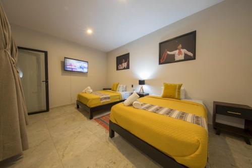 a hotel room with two beds and a tv at Casa Tonalli Boutique in Mexico City