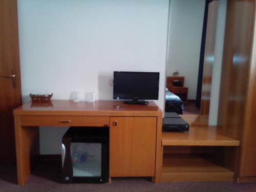 a desk with a television on top of it at Hotel Niki in Tribiano