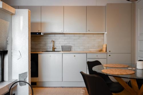 a kitchen with white cabinets and a table with chairs at Rinneköngäs - Ruka-Pyhä 2x SKIPASS included - Free Skibuss Doorstep - Renovated in Ruka