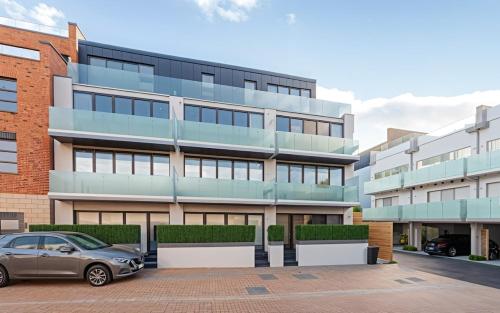 a car parked in front of a building at The Wimbledon Collection 2 Bed Apartments in London