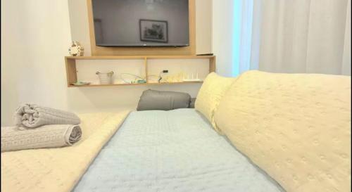 a bedroom with a bed with a tv on the wall at Estrela Do Mar flat Beach in Porto De Galinhas