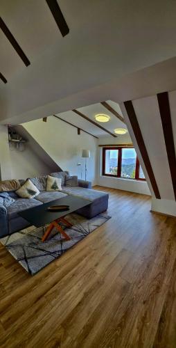 a living room with a couch and a table at The Pine Loft by Kopaonik in Kopaonik