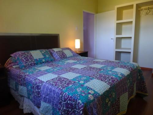 a bedroom with a bed with a quilt on it at Apart Hotel La Bodega in San Rafael