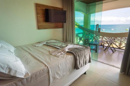 a bedroom with a bed and a view of the ocean at Pousada Porto 23 in Morro de São Paulo