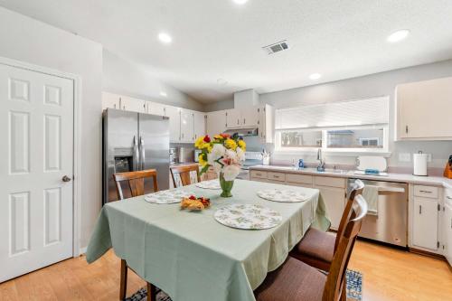 a kitchen with a table with a vase of flowers on it at Life's a Breeze - 5min to Pcola Beach , Families in Gulf Breeze