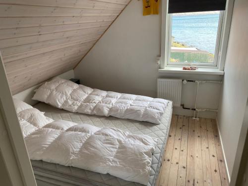 a bedroom with two beds and a window at Ocean view from front parquet in Oyndarfjørður