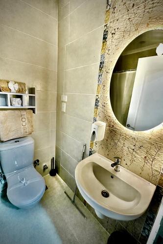 a bathroom with a sink and a toilet and a mirror at Heritage Cairo Hotel Taalat Harb in Cairo