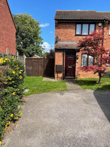 a brick house with a driveway in a yard at Cosy 2bed house in Oxford, sleeps 4 and a baby in Oxford