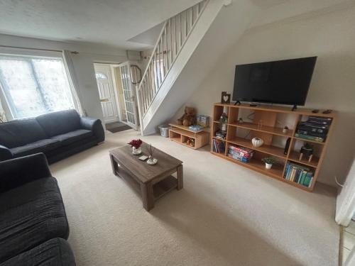 a living room with a couch and a tv at Cosy 2bed house in Oxford, sleeps 4 and a baby in Oxford