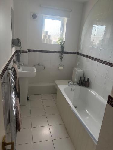 a white bathroom with a tub and a sink at Cosy 2bed house in Oxford, sleeps 4 and a baby in Oxford