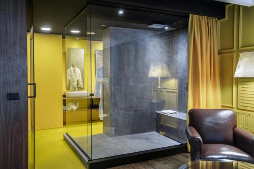 a glass shower in a room with a chair at Park Hotel & Spa in Skopje