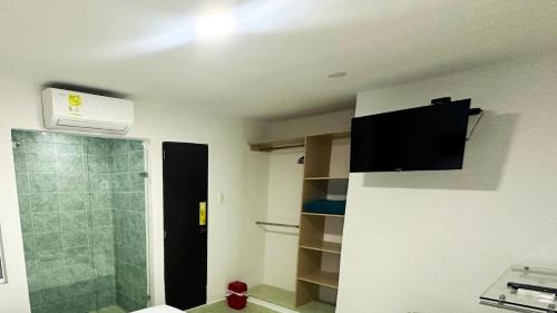 a bathroom with a shower and a television on the ceiling at Hotel Casa Paraiso in Barranquilla