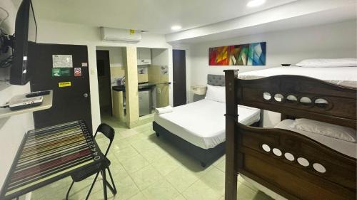 a room with two bunk beds and a kitchen at Hotel Casa Paraiso in Barranquilla