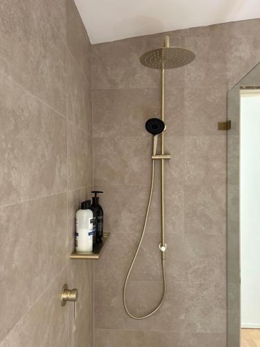 a shower with a shower head in a bathroom at Bronte Cottage in Lawson
