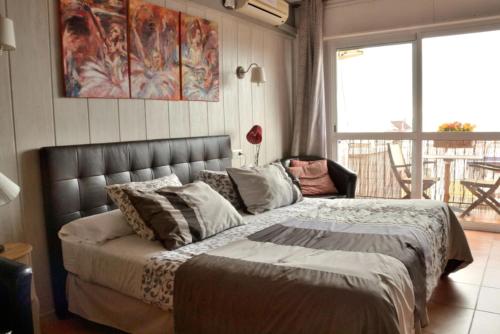 a bedroom with a bed and a large window at Hostal Don Peque in Nerja
