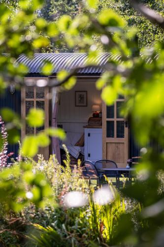ein Haus mit Tisch und Stühlen in einem Garten in der Unterkunft Peatlands Retreat, Causeway Coast in Ballybogy