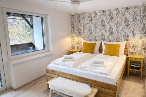 a bedroom with a large bed with yellow pillows at Penzion Pibernik in Bled