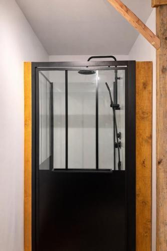 a glass door with a shower in a room at Le Clair-Obscur in Paray-le-Monial
