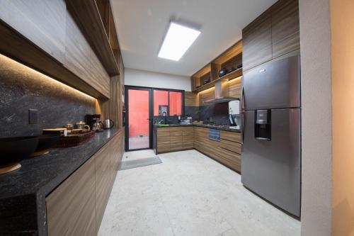 a kitchen with a stainless steel refrigerator and wooden cabinets at Casa Tonalli Boutique in Mexico City