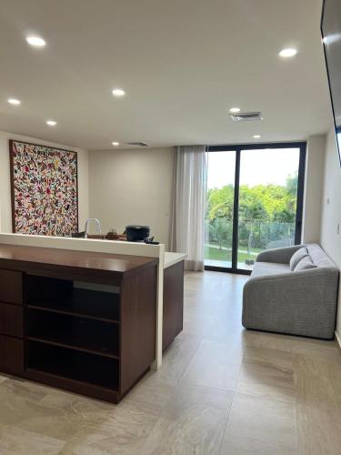 a large living room with a couch and a kitchen at Modern studio in a waterfront building in Cozumel