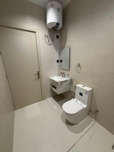 a white bathroom with a toilet and a sink at نسيم العلا - Naseem AlUla in Al-ʿUla
