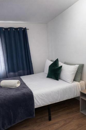 a bed with white and green pillows in a room at Mary House London in Edmonton
