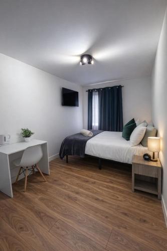 a bedroom with a bed and a desk and a desk at Mary House London in Edmonton
