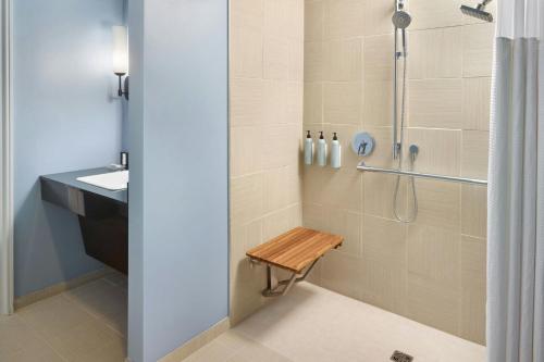 a bathroom with a shower with a bench in it at Courtyard by Marriott New Orleans French Quarter/Iberville in New Orleans