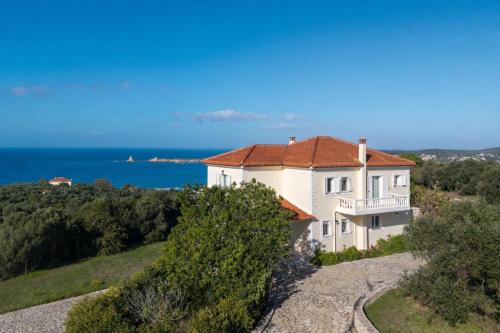 a house on a hill with the ocean in the background at Villa Aether Methoni in Methoni