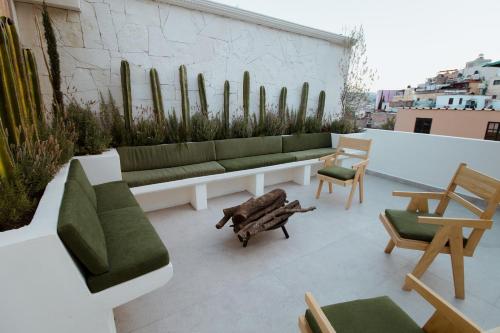 a rooftop patio with a couch and chairs and cactus at Bernardino Boutique Hotel in Guanajuato
