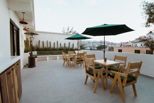 a patio with tables and chairs and an umbrella at Bernardino Boutique Hotel in Guanajuato