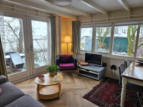a living room with a couch and a tv at Lovely holiday house in Durgerdam in Amsterdam
